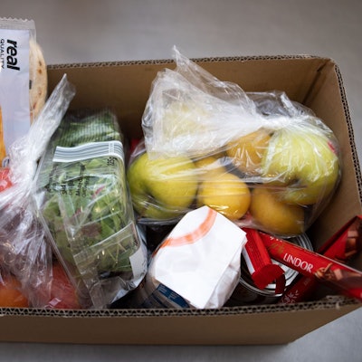 Ein Karton mit Lebensmitteln steht in den Räumen der Aachener Tafel.