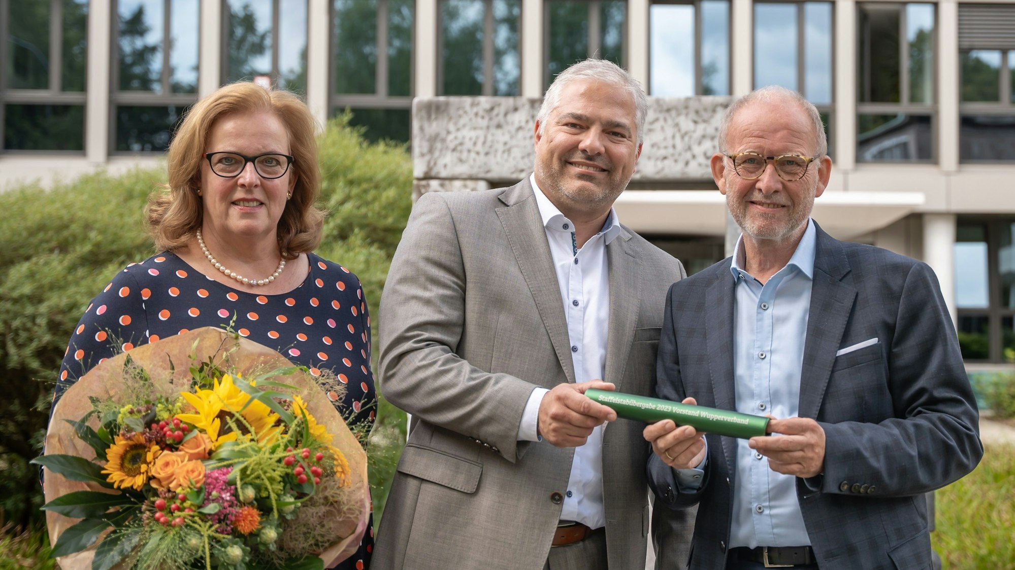 Verbandsratsvorsitzender Claudia Fischer (mit Blumenstrauß), der neue Vorstand Ingo Noppen (M.) und sein Vorgänger Georg Wulf beim Amtswechsel.
