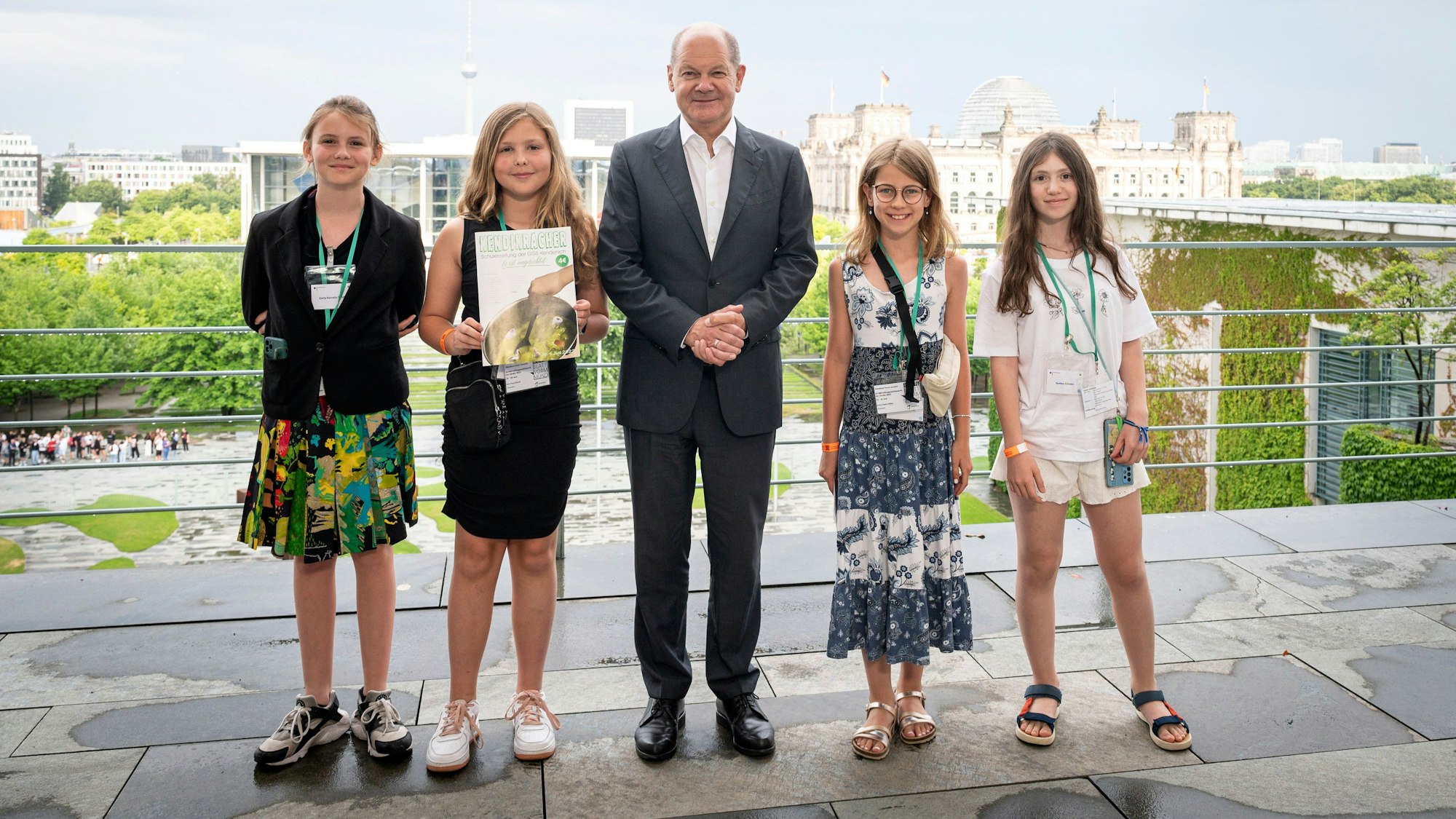 Olaf Scholz und die vier Mädchen, die für ihre Schülerzeitung ausgezeichnet wurden, stehen auf einer Terrasse.