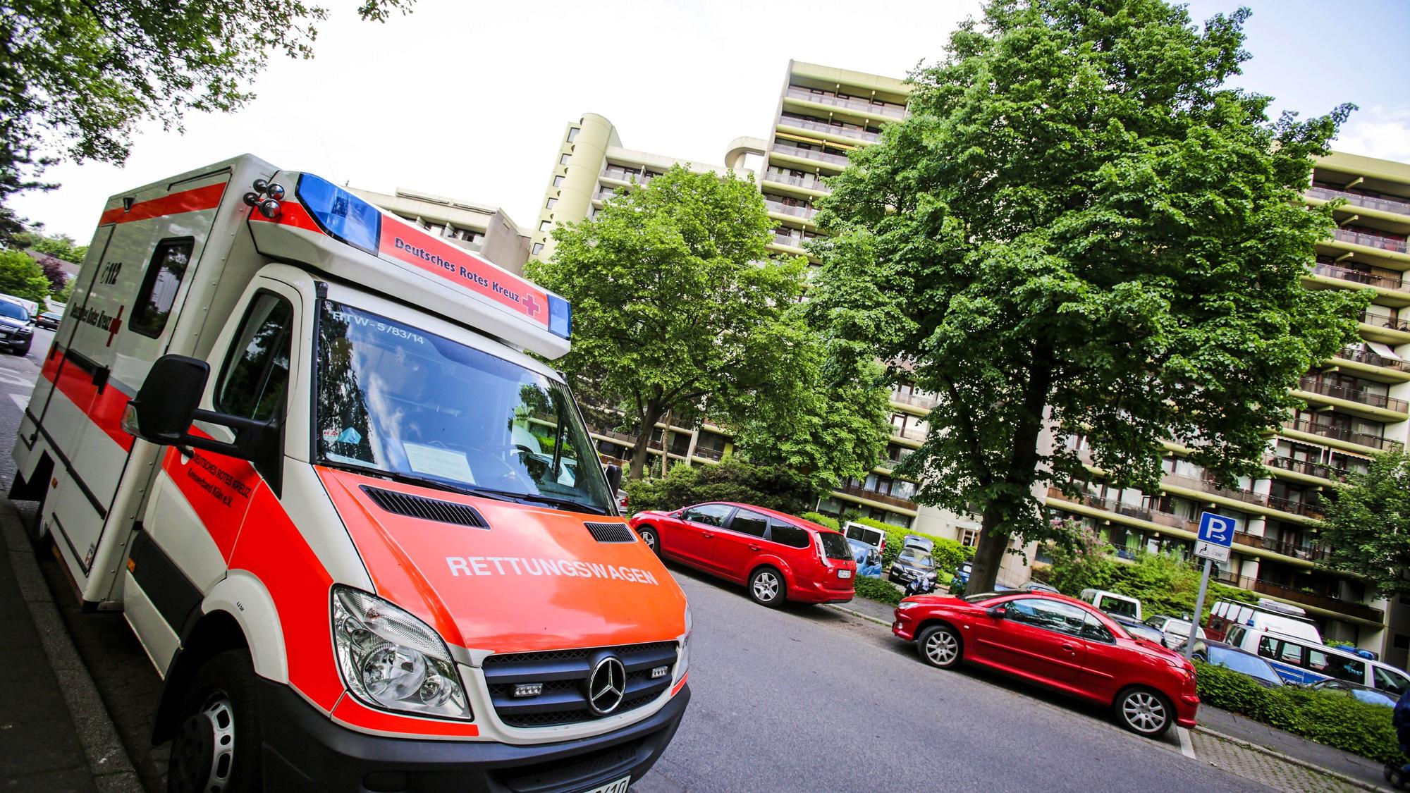 Ein Rettungswagen des Deutschen Roten Kreuz steht vor einem Wohnhaus.