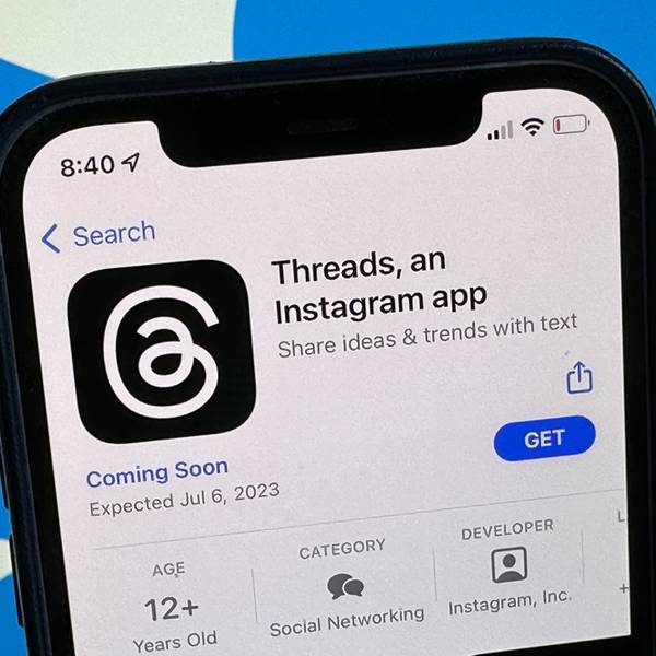 Die Ankündigung der Social-Media-App Threads wird im US-amerikanischen App Store von Apple angezeigt. Im Hintergrund ist das Twitter-Logo zu sehen.
