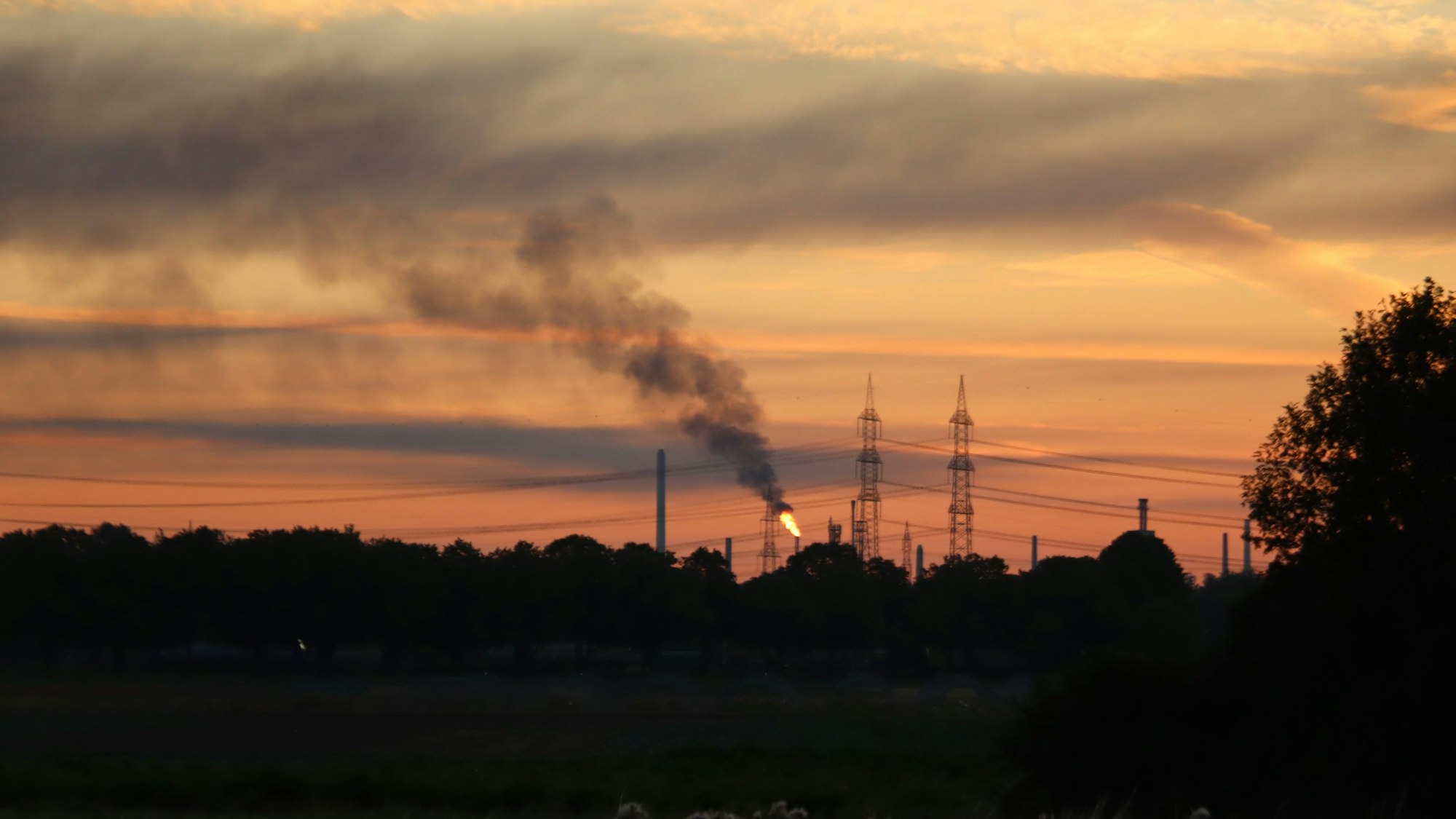 Das Bild zeigt einen Sonnenaufgang über der Industriekulisse von Wesseling.