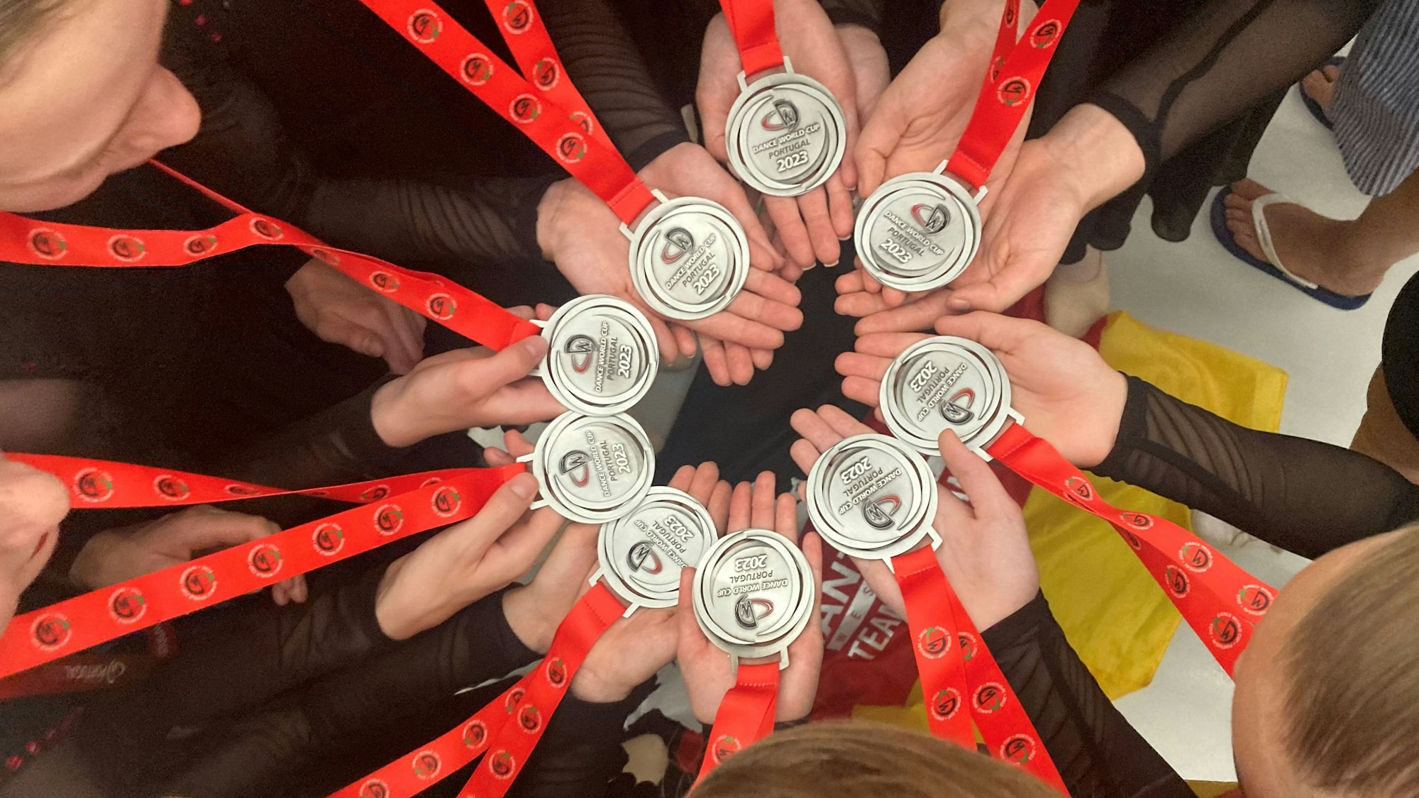 Mädchen halten ihre Medaillen vom Dance World Cup in die Kamera.