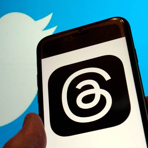 Blick auf das Logo für Metas neue App Threads auf einem Handy-Display und das Logo von Twitter.