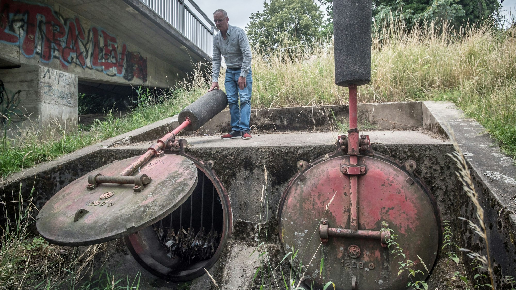 Große Klappen: Friedrich Jonas an den beiden Rückschlagklappen an der Dhünn, aus denen bei Regen das Abwasser von der Stelze in den Fluss rauscht.