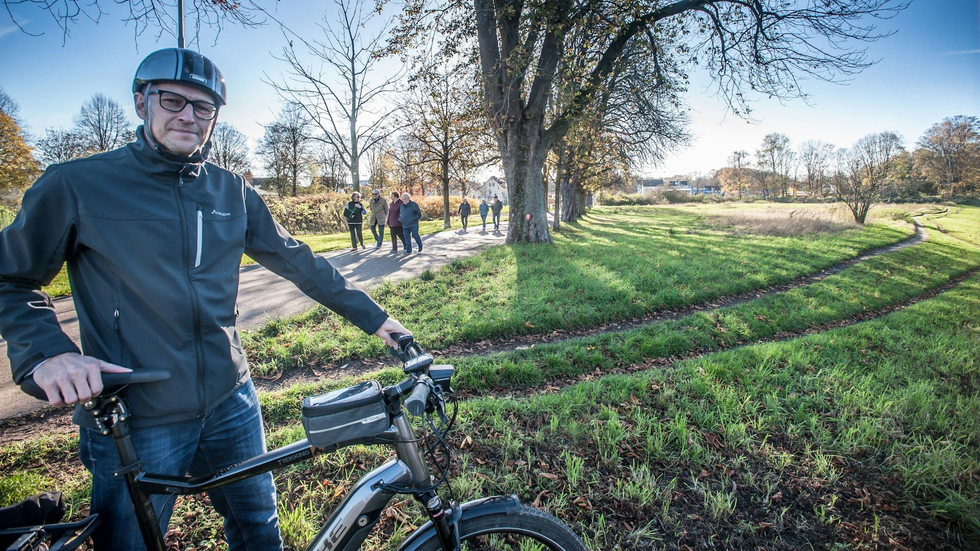 Der Opladener Matthias Itzwerth steht mit seinem Fahrrad an einer Wiese.