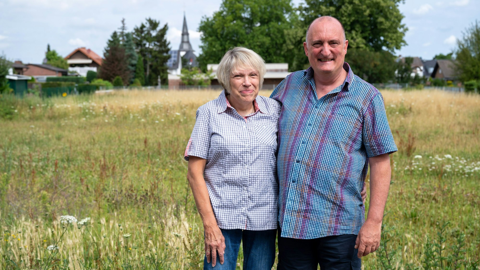 Das Ehepaar Eich steht vor seinem neuen Grundstück in Erftstadt-Erp. Das Haus der beiden ist bei der Flutkatastrophe an der Erft in den Kiesgrubenkrater in Blessem gestürzt.