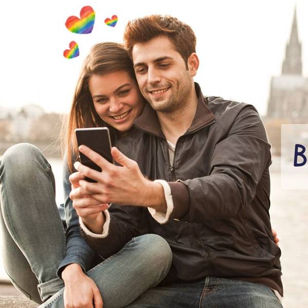Eine Frau und ein Mann stehen auf der Rheinpromenade mit dem Kölner Dom und der Hohenzollernbrücke im Hintergrund und schauen lächelnd auf ein Smartphone. Daneben das Logo der Website Bütz mich.
