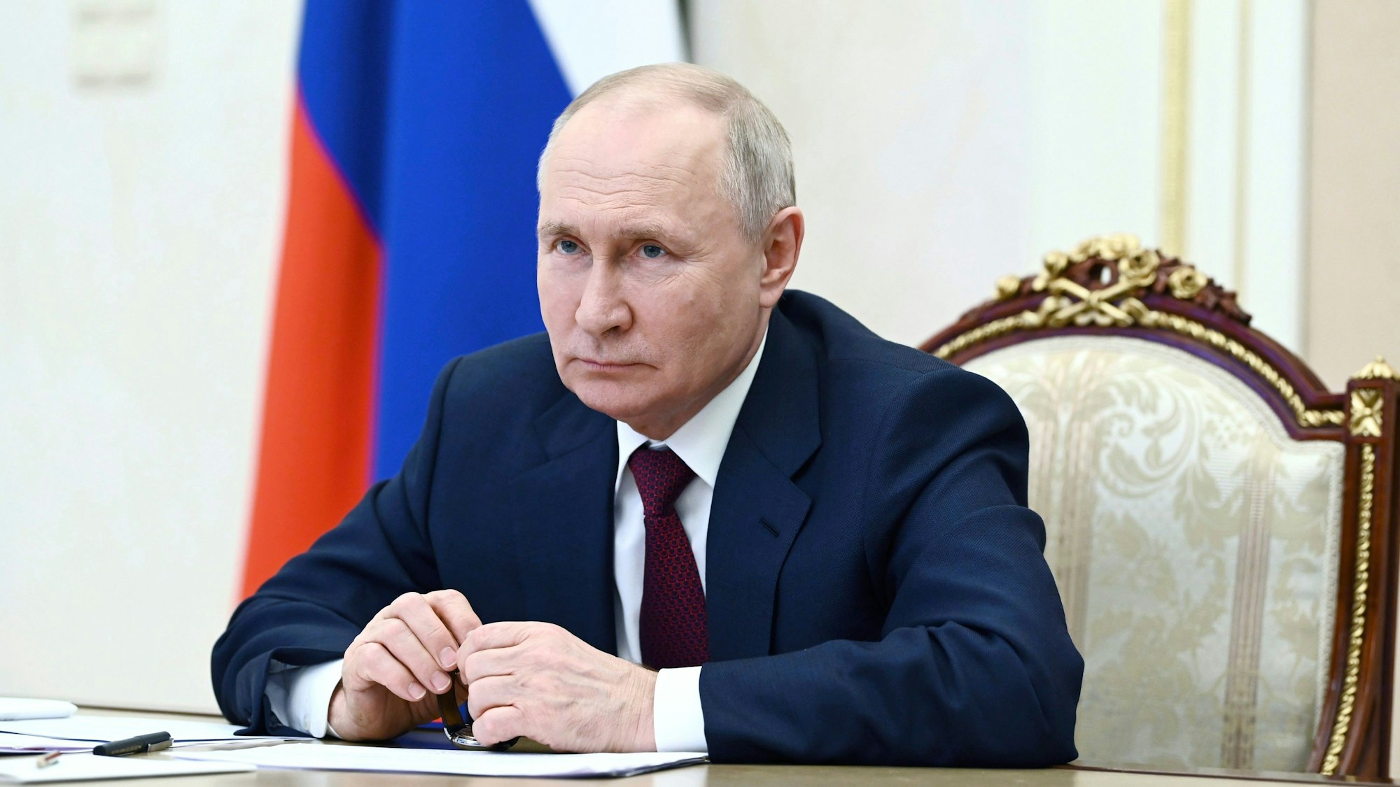 Der russische Präsident Wladimir Putin bei einer Sitzung seines Kabinetts im Kreml in Moskau. Er sitzt an dem berühmten langen Tisch, hinter ihm eine russische Flagge.