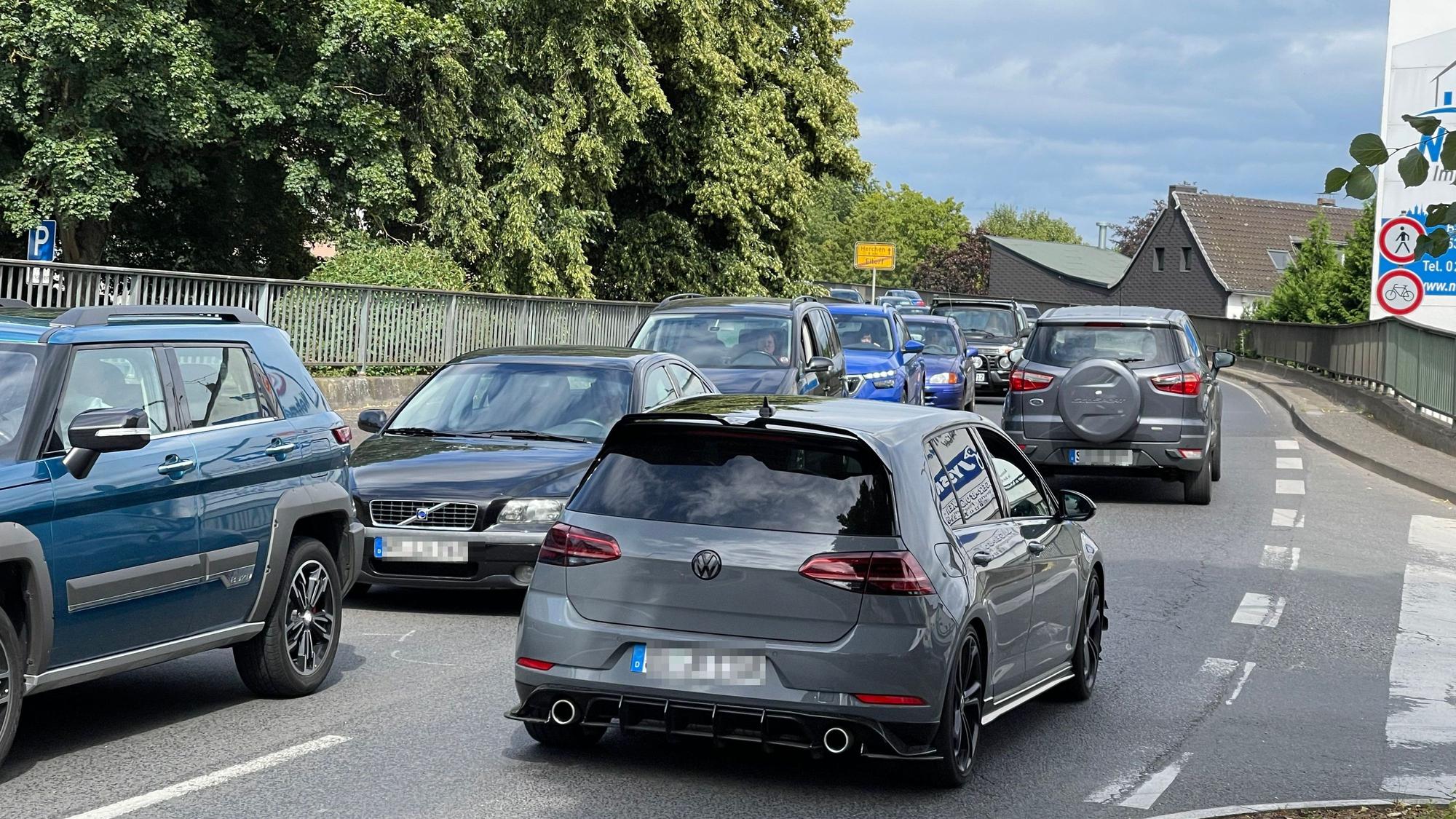 Auf einer Brücke ist ein langer Rückstau, auch die Gegenfahrbahn ist stark befahren.