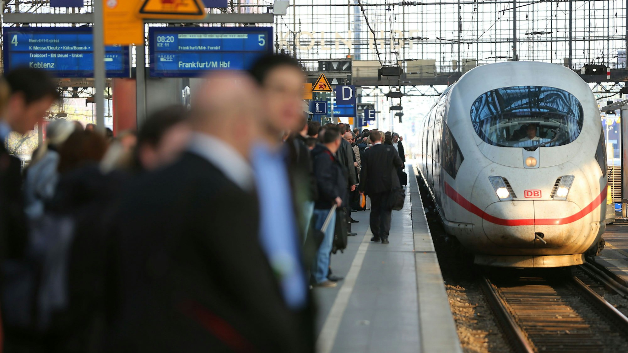 Reisende warten am Kölner Hauptbahnhof auf einen ICE der Deutschen Bahn.