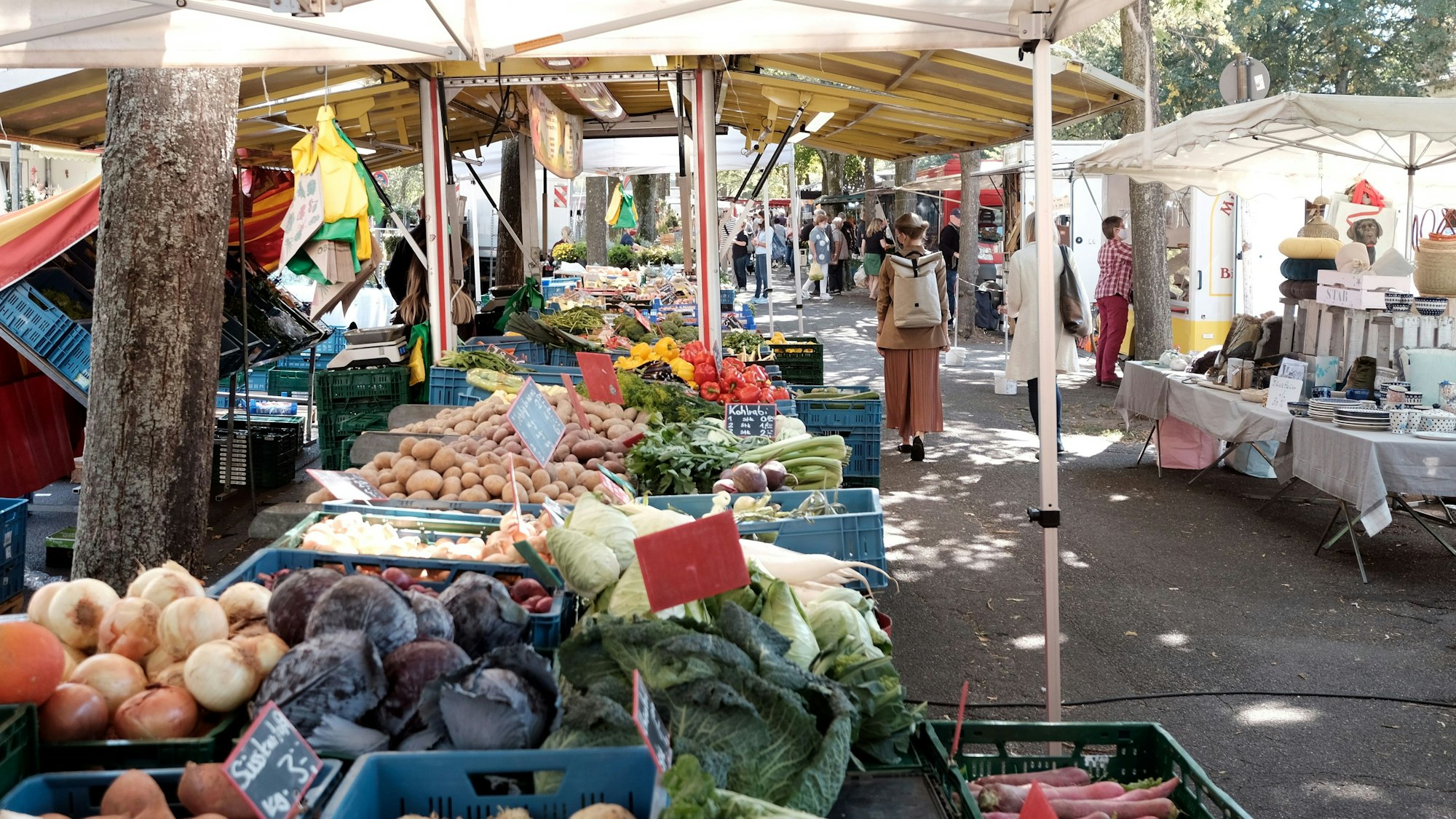 Gemüsestände und andere sind an einer Straße aufgereiht.