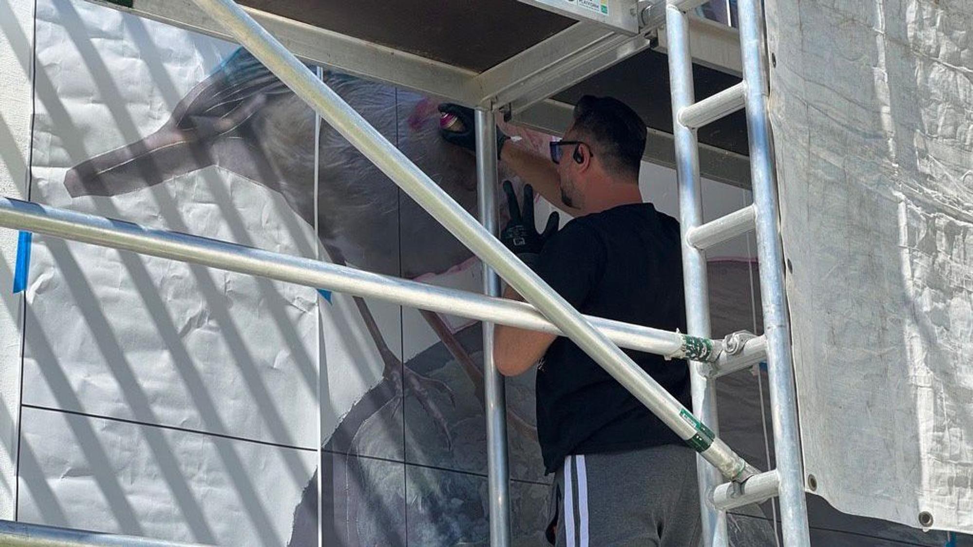 Der Leichlinger Künstler Eike Conzen alias Tank sprayt sein Bild an die Hausfassade eines ökologisch sanierten Fachwerkhauses.
