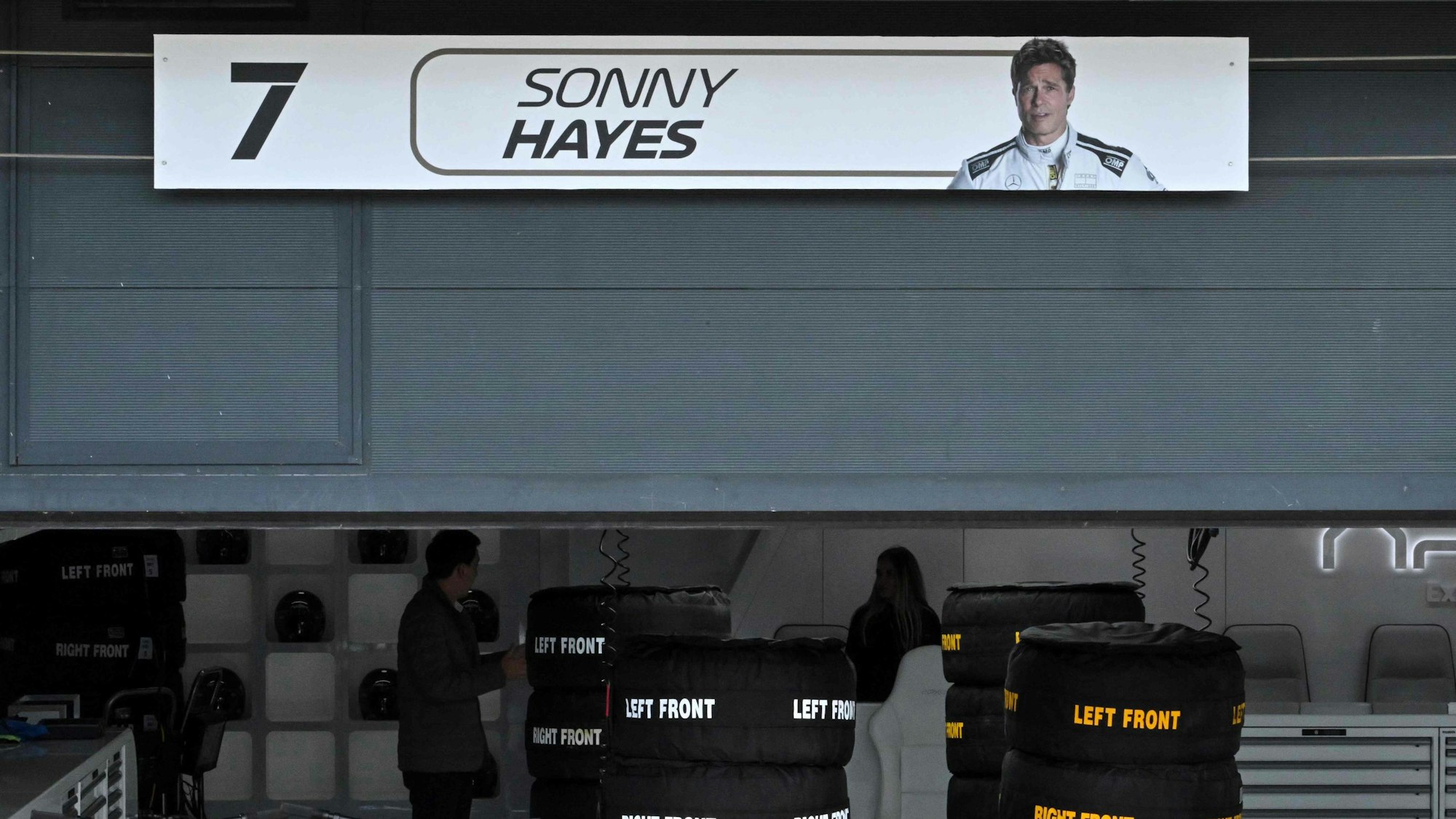 Ein Schild mit dem Bild des US-Schauspielers Brad Pitt, der in einem von der Formel 1 inspirierten Film Sonny Hayes, den Fahrer des fiktiven Apex-Teams, spielt, hängt über seiner fiktiven Garage vor dem Großen Preis von Großbritannien auf der Silverstone-Rennstrecke in Silverstone, Mittelengland, am 6. Juli 2023.