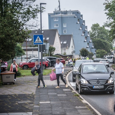 Eltern bringen ihre Kinder mit dem Auto zur Schule.