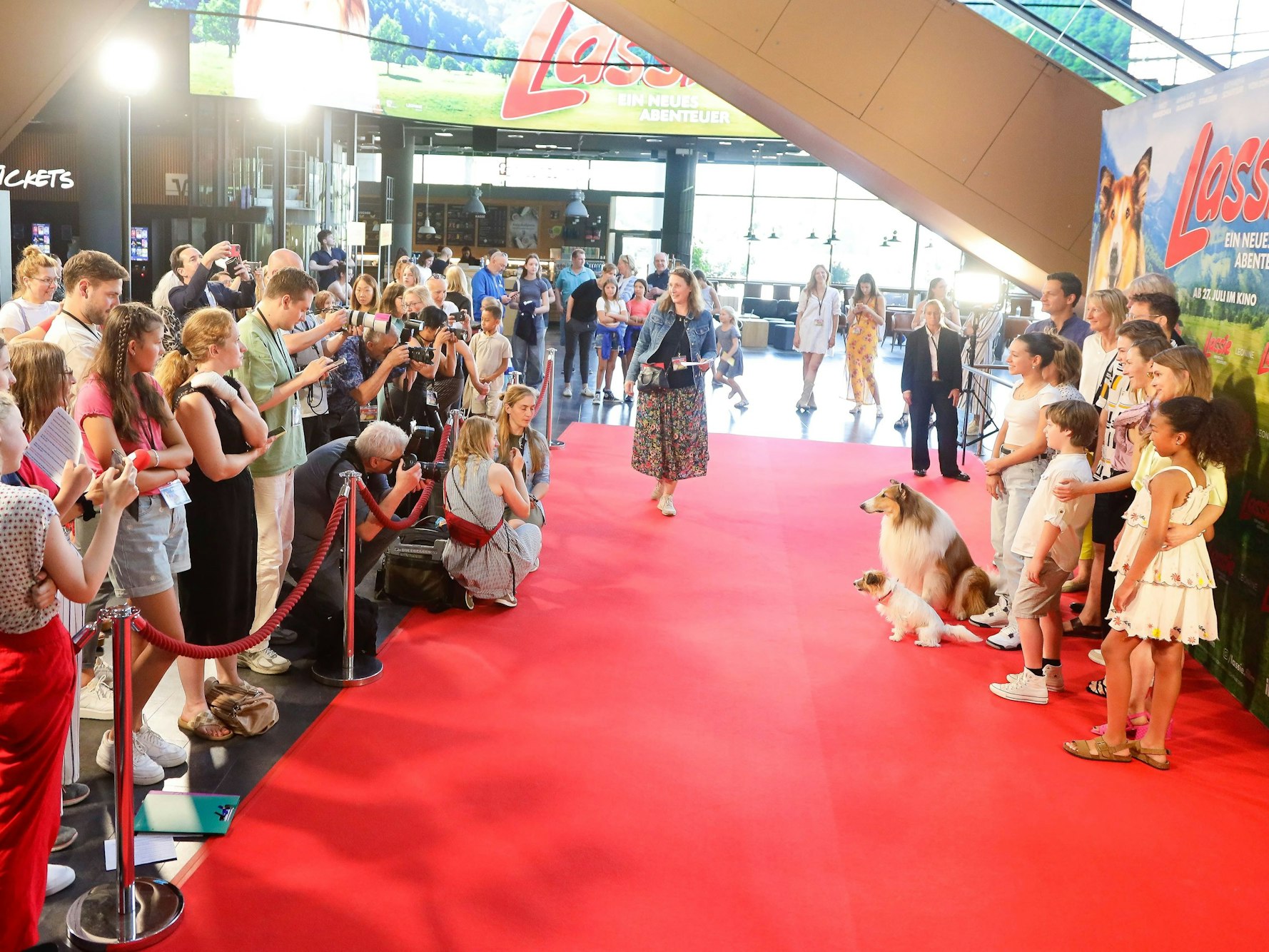 Viele Menschen stehen vor dem Roten Teppich, darauf die Filmcrew mit Hunden.