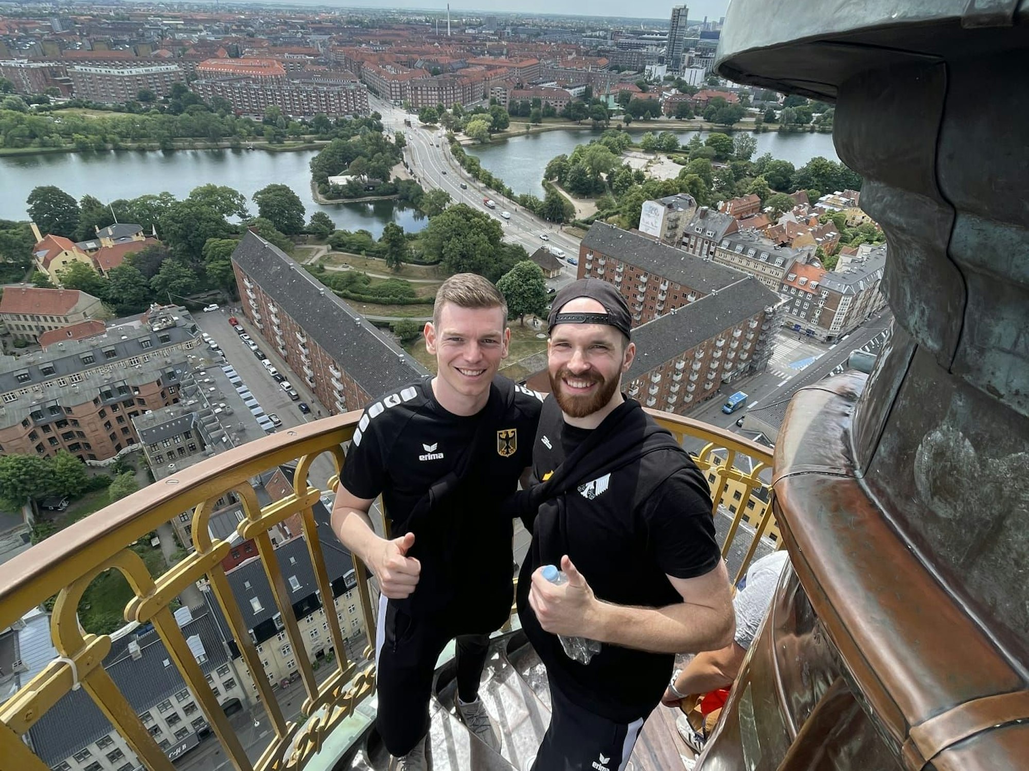 Dieses Selfie zeigt die Handball-Nationalspieler Dominik Götz und Simon Schöller, die auf der Treppe zur Erlöserkirche stehen, im Hintergrund der Ausblick über Kopenhagen.