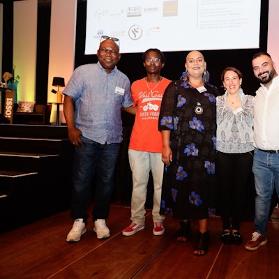 Mehrere Personen stehen Arm in Arm nebenbeinander.