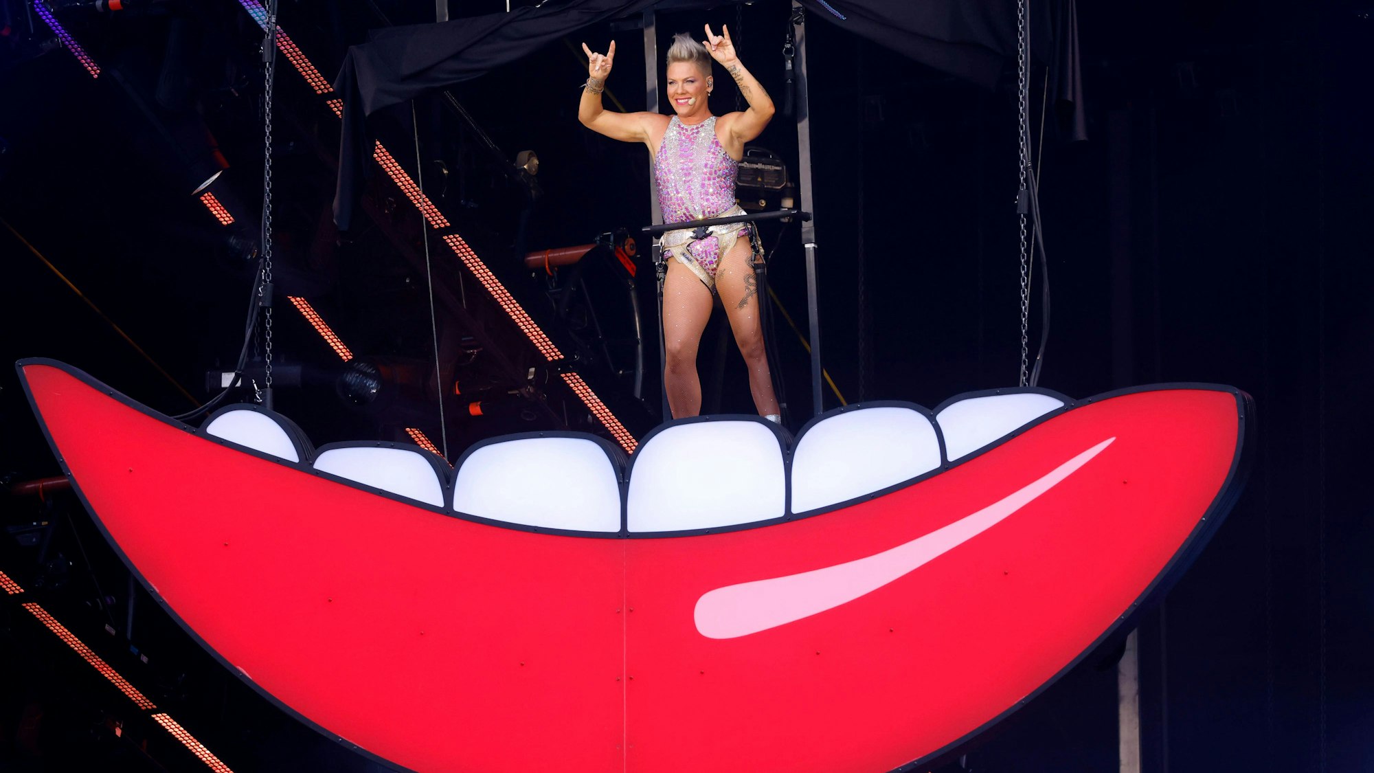 Sängerin Pink steht auf Bühnenteil, das einen Mund mit Zähnen darstellen soll.