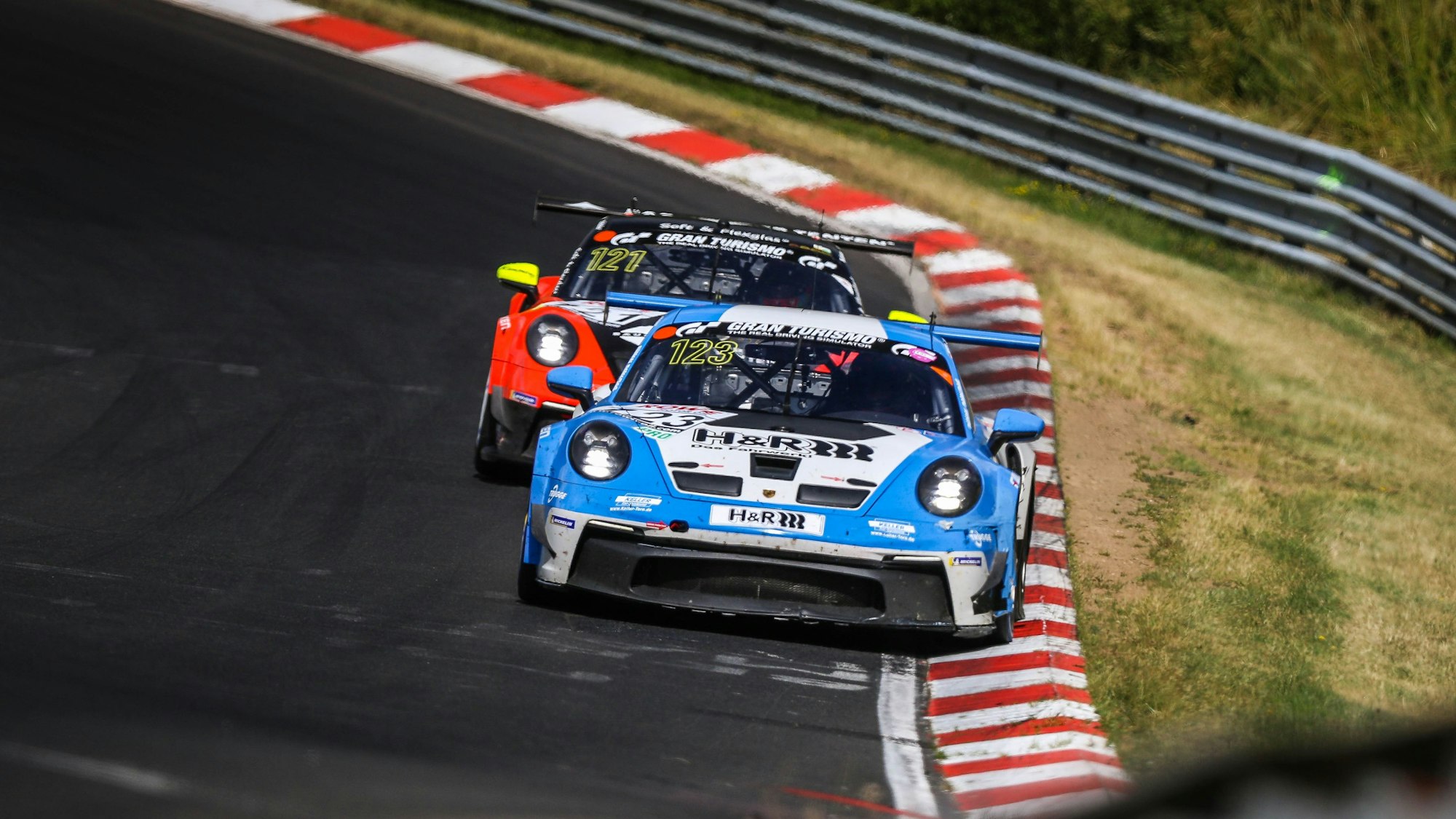 Die beiden Rennwagen fahren dicht hintereinander.