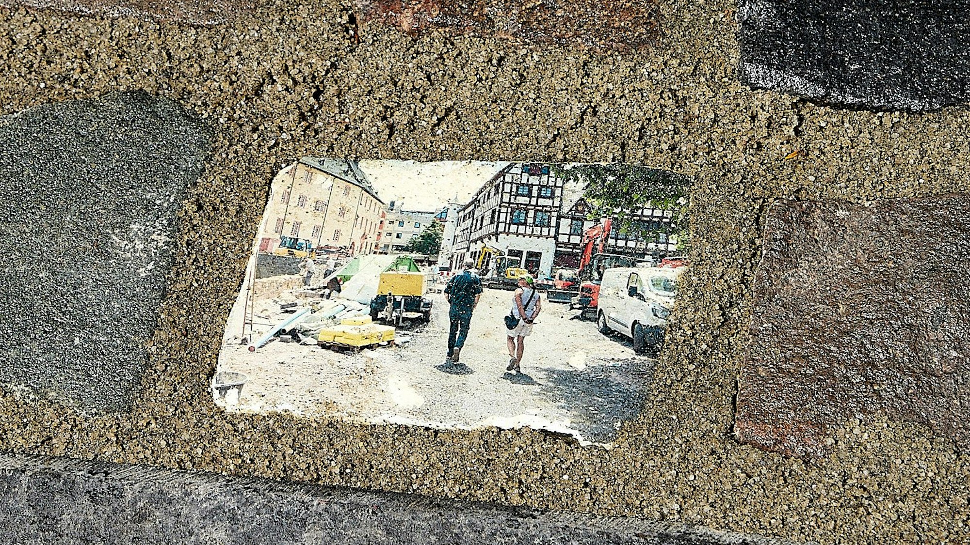 Das Bild zeigt mehrere Pflastersteine in Bad Münstereifel. Der Mittlere ist mit einem Motiv aus den Tagen nach der Flutkatastrophe bedruckt.