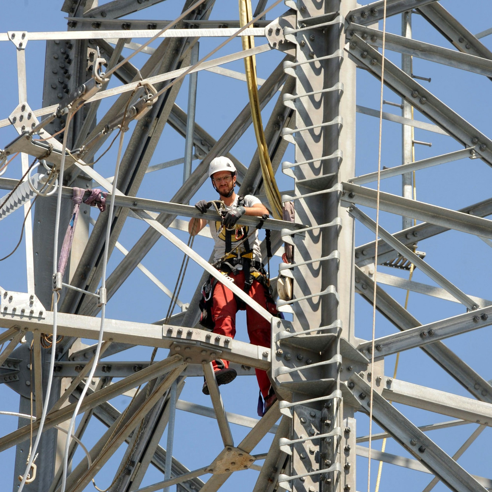 Das Bild zeigt einen Monteur auf einem Strommast.