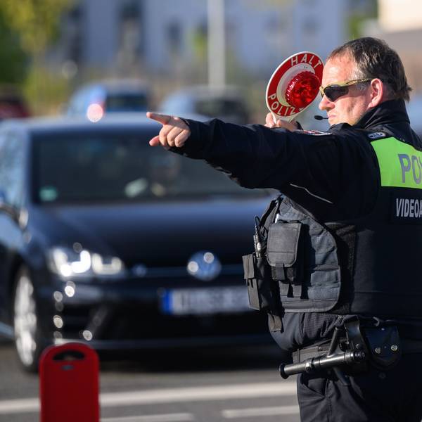Ein Polizist winkt Autofahrer zu einer Kontrolle raus.