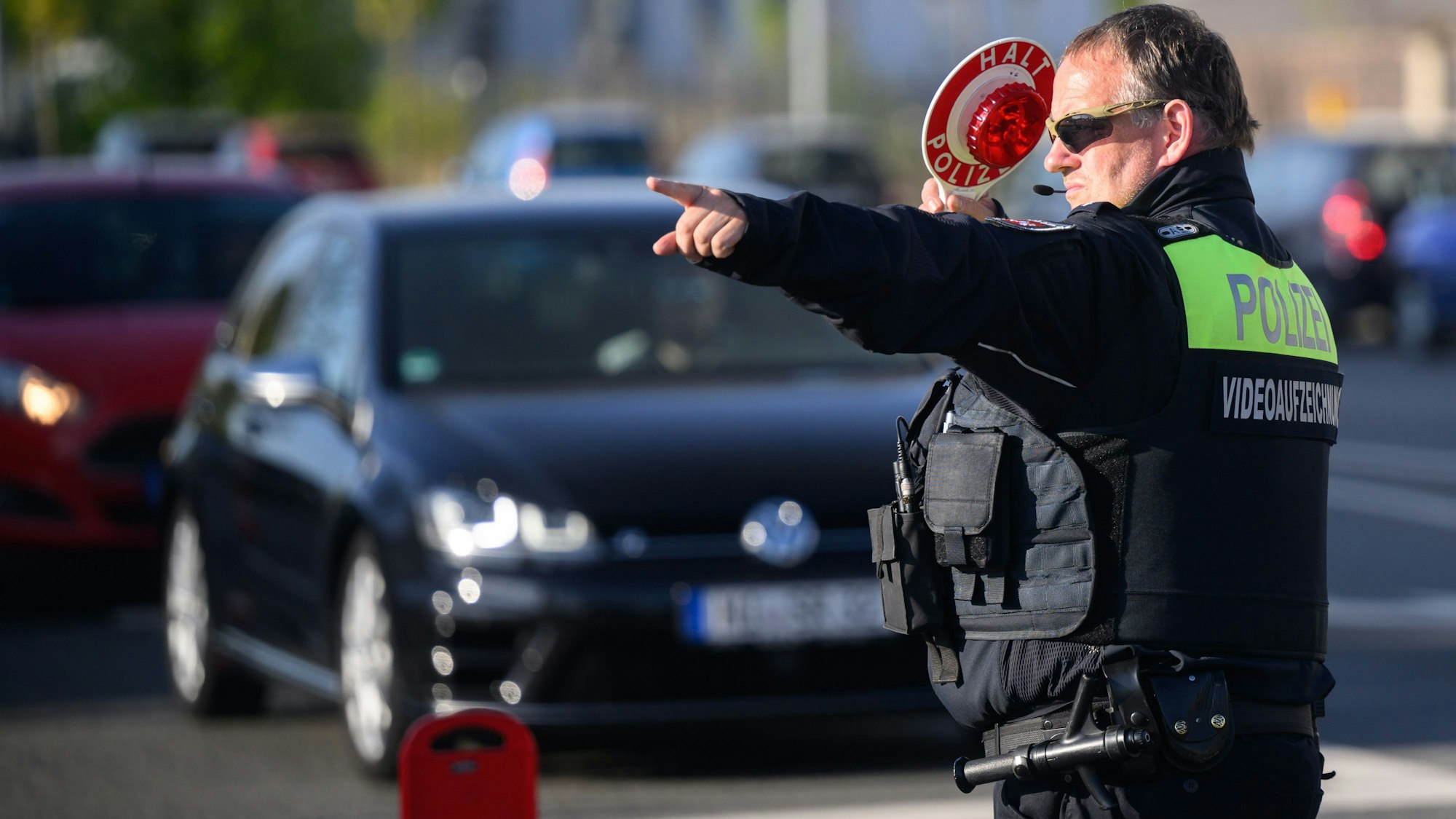 Ein Polizist der Polizei Hildesheim winkt Autofahrer zu einer Kontrolle raus.