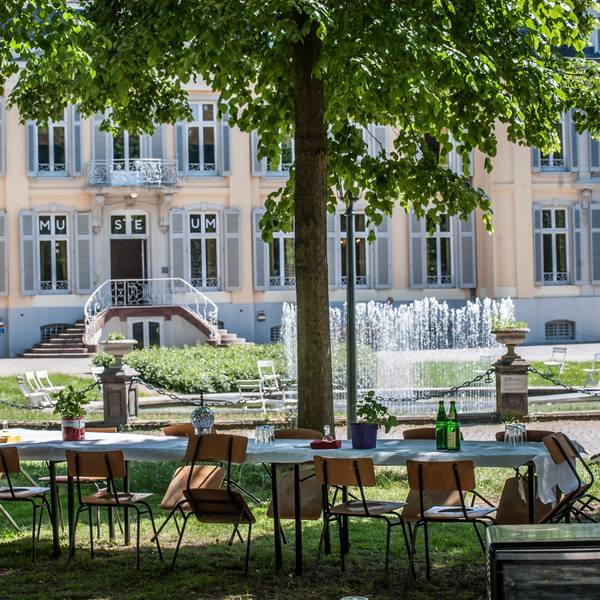 Lange Tafel mit Stühlen vor dem Schloss Morsbroich.