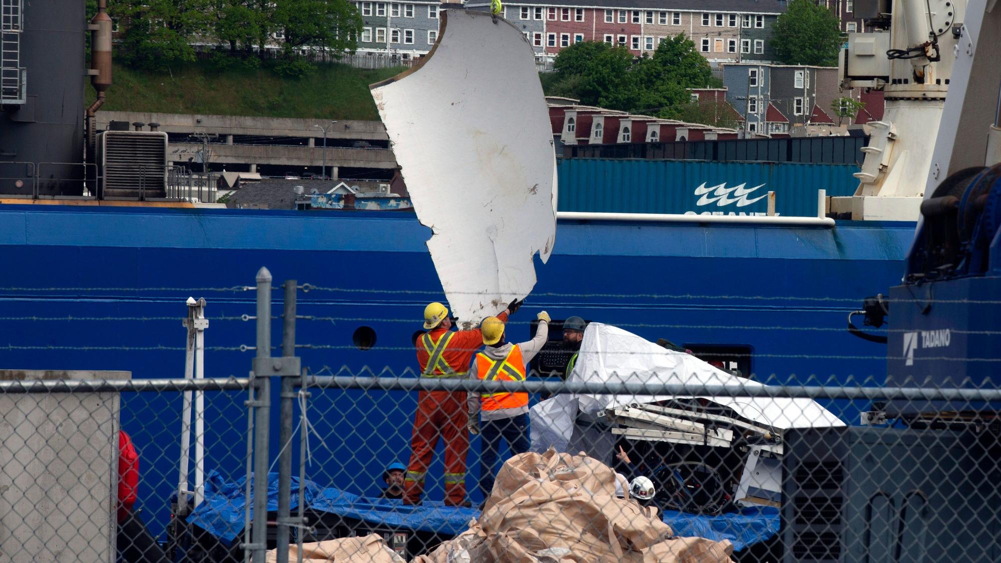 Arbeiter bergen und verstauen Trümmerteile des implodierten Unterseeboots „Titan“ der Firma OceanGate am 28. Juni.