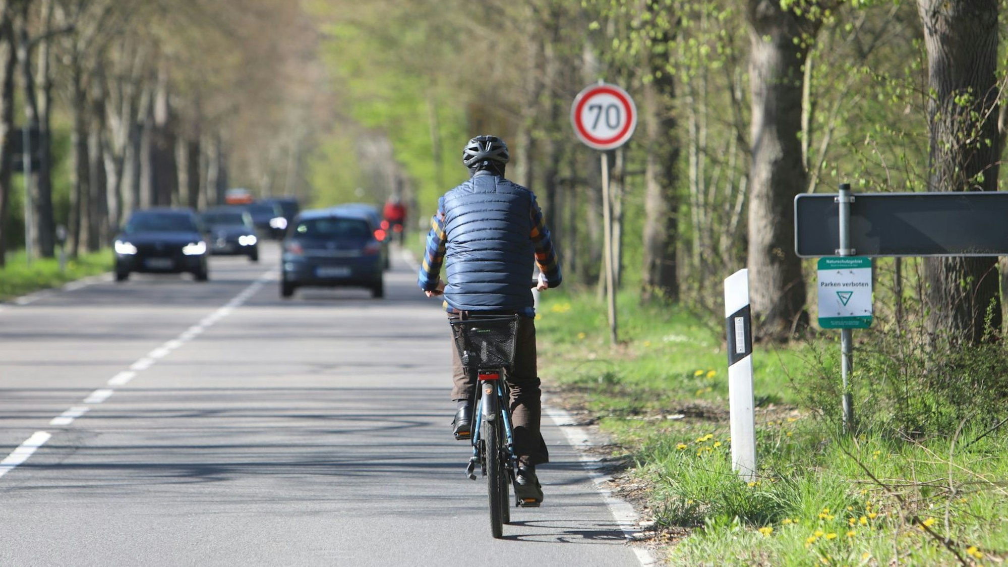 Ein Radfahrer fährt die Landesstraße 268 bergauf in Richtung Kloster Heisterbach. Ihm kommen Autos entgegen.