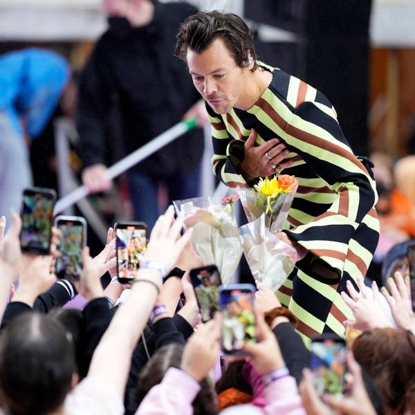 Harry Styles bei einem Auftritt in New York. Er nimmt Blumen entgegen.