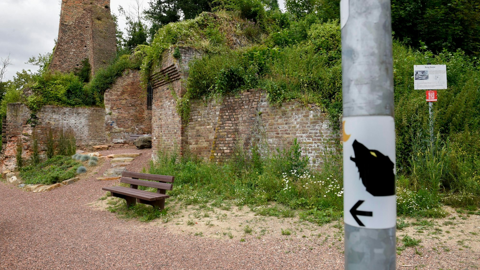 Man sieht den Wanderweg und einen Sticker, auf dem der Werwolf abgebildet ist. Darunter ein Pfeil.