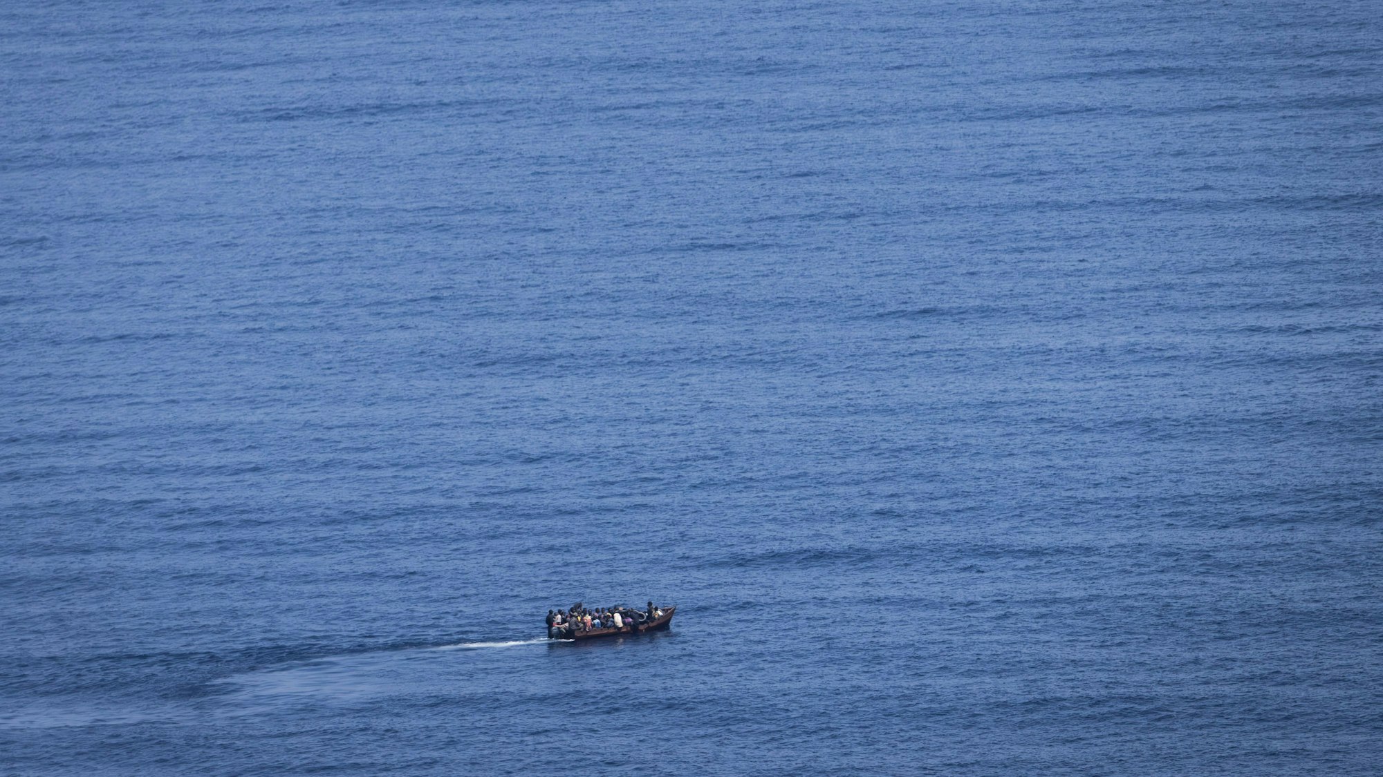 Migranten steuern ein Boot über das Mittelmeer (Symbolbild). Im Atlantik suchen Rettungskräfte nach 200 vermissten Migranten.