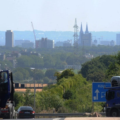 Das Bild zeigt einen Hochspannungsmast vor dem Kölner Dom