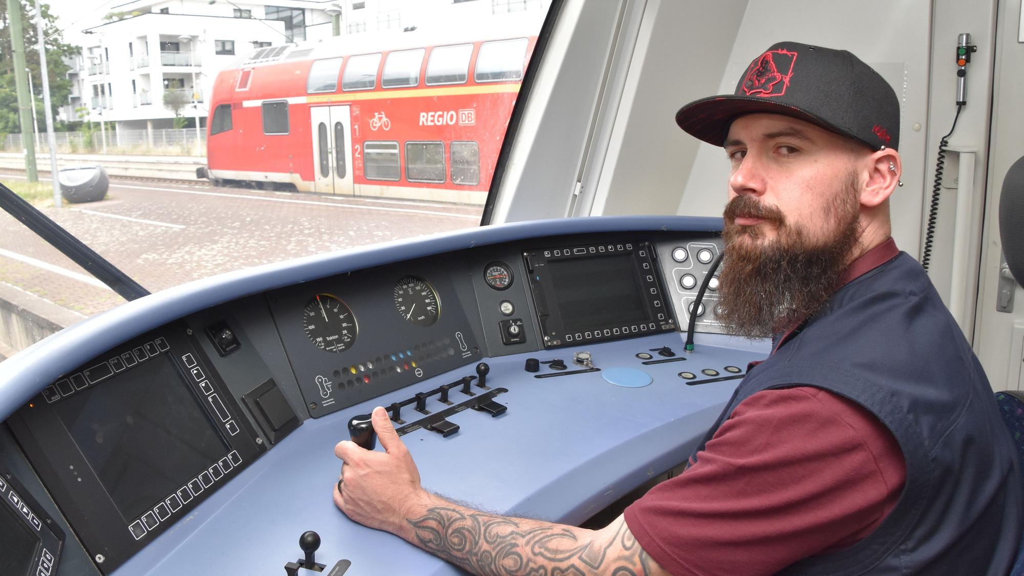 Ein Mann sitzt im Führerstand eines Zuges.