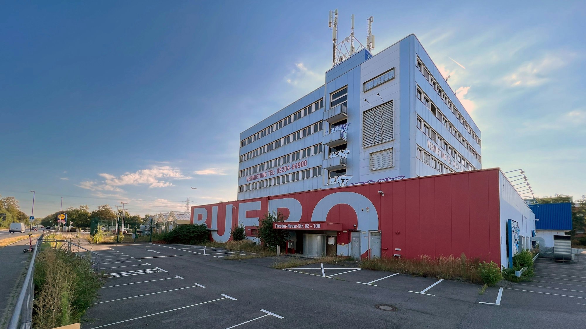 Das leerstehende Gebäude mit Parkplätzen davor.