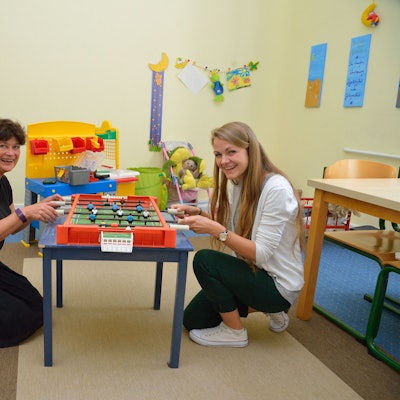 Katrin Fassin und Annika Nern vom Kinderschutzbund sitzen an einem mobilen Tischkicker im Spielraum.