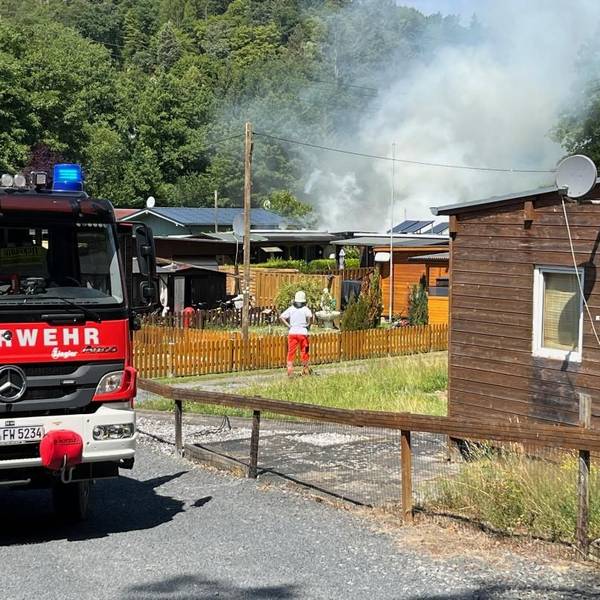 Feuerwehrleute im Einsatz auf einem Campingplatz.
