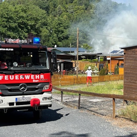 Feuerwehrleute im Einsatz auf einem Campingplatz.
