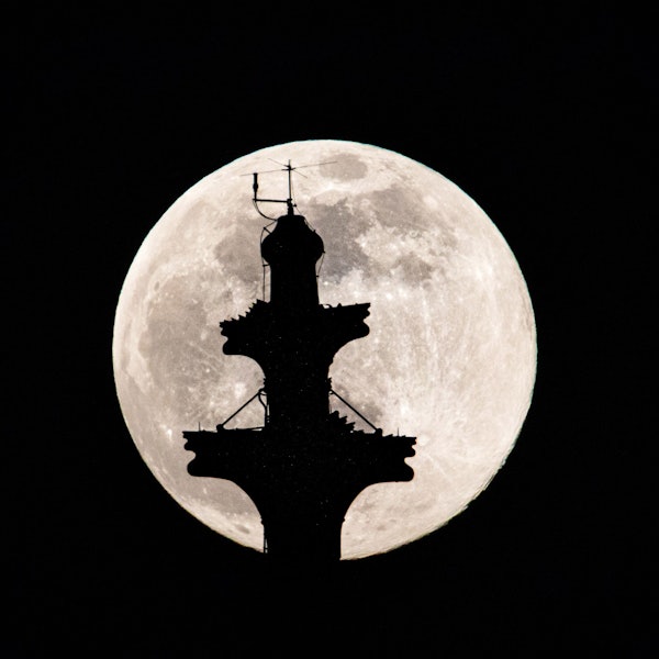 Der Vollmond steht hinter der Kreuzblume auf dem Nordturm des Kölner Doms.
