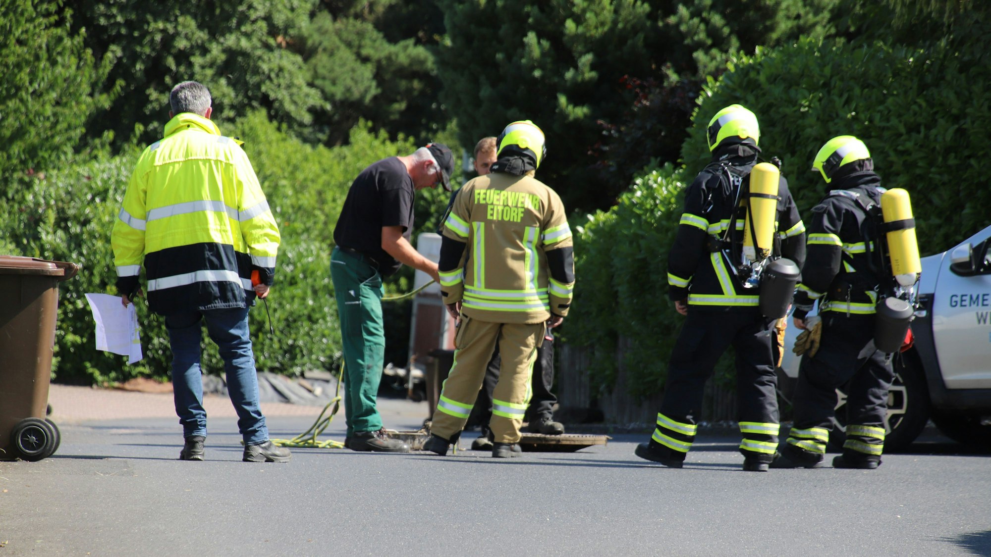 Feuerwehrleute begutachten einen Kanalschacht.
