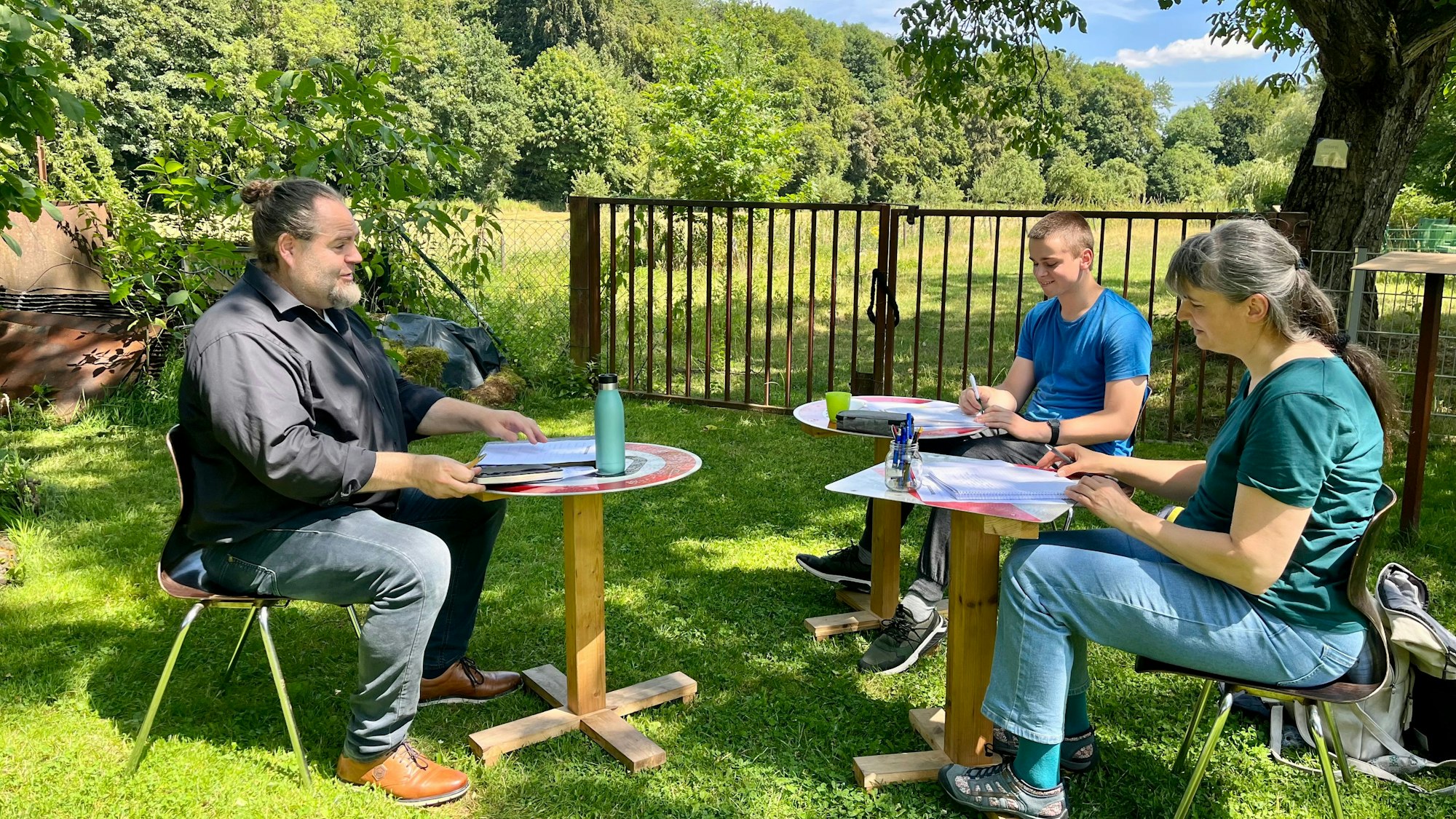 Christian Linker (l.) mit Anja und Gerald Schellenberg in der Schreibwerkstatt des Sensenhammers.