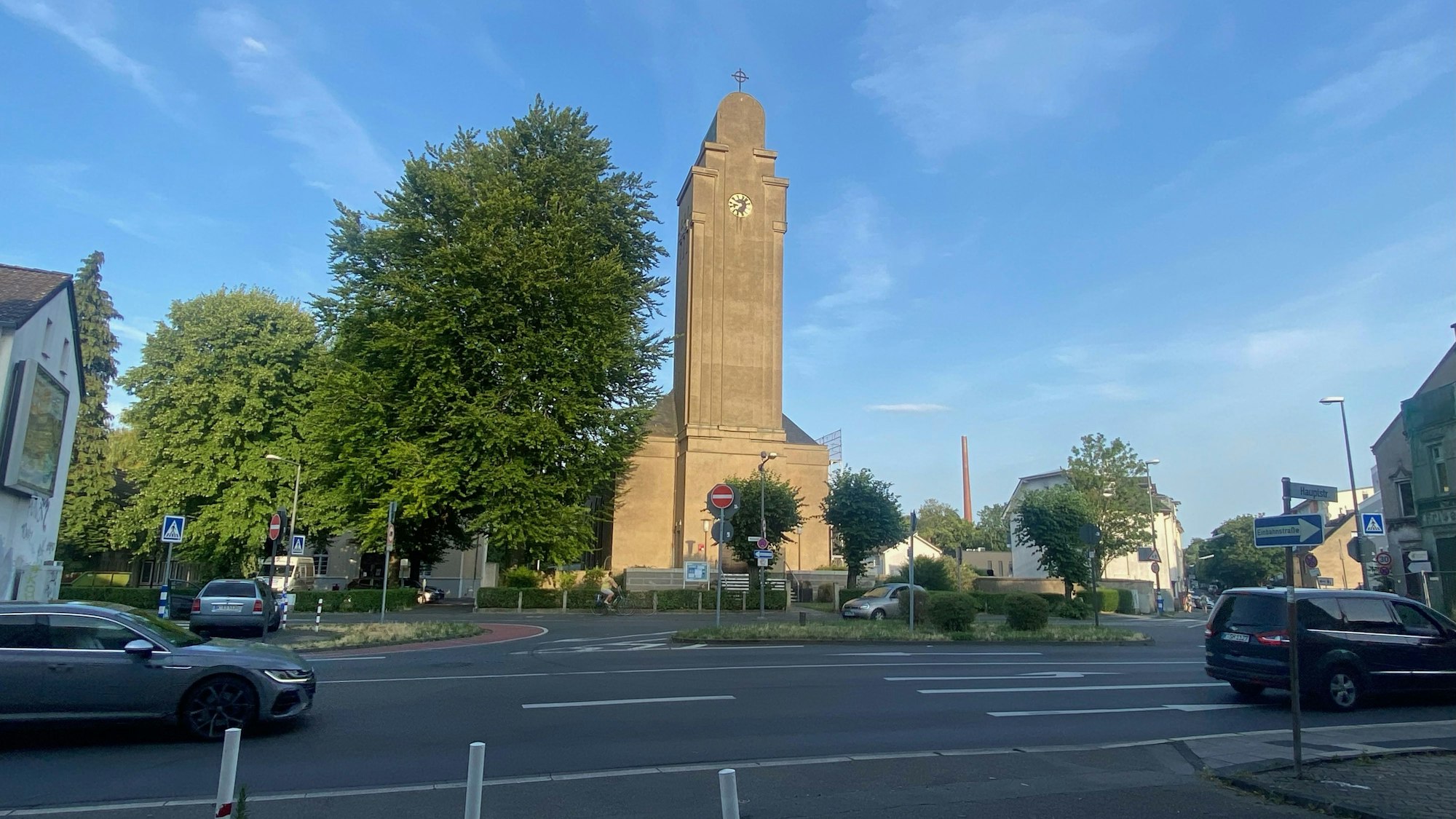 An einer mehrspurigen Straße ist frontal ein Kirchengebäude zu sehen.