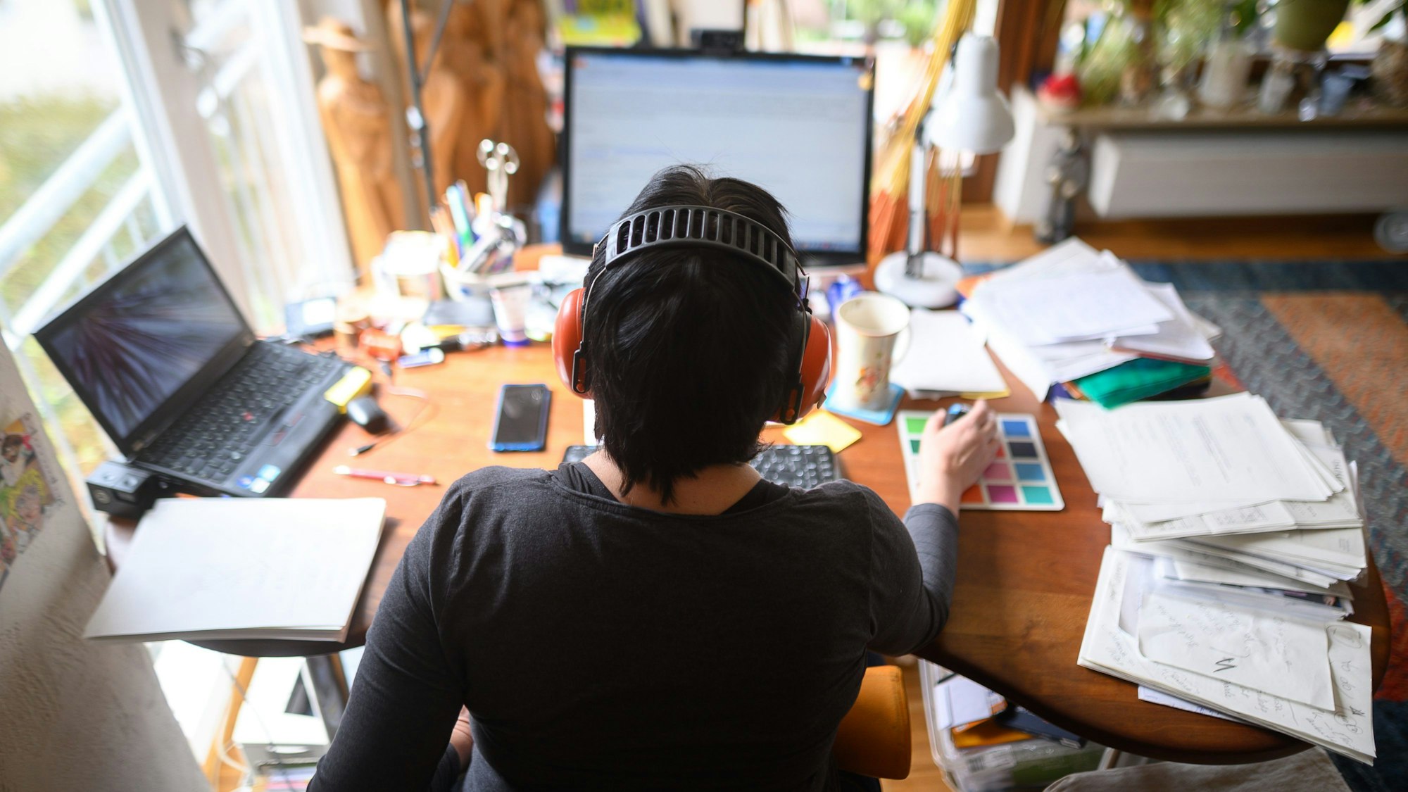 Eine Frau arbeitet, wie Millionen Deutsche auch, im Homeoffice. Sind die Menschen dort unproduktiver? Oder sogar tüchtiger als im Büro? Studien kommen zu unterschiedlichen Ergebnissen. (Symbolbild)