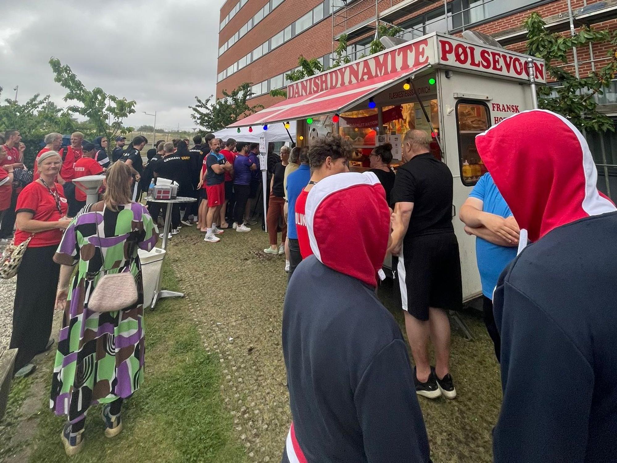 Die WM-Teilnehmer stehen um einen Streetfood-Truck herum und warten auf Hotdogs.