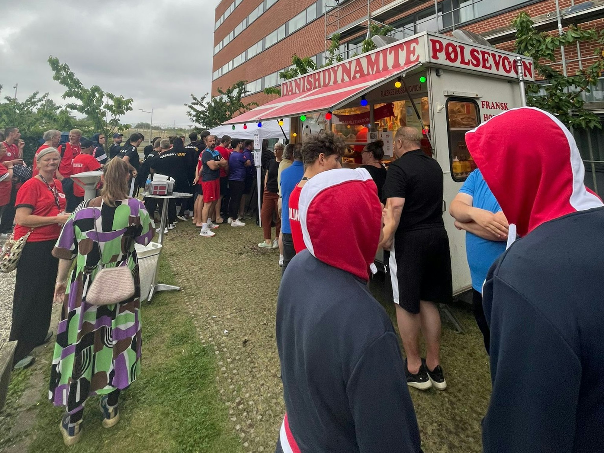Die WM-Teilnehmer stehen um einen Streetfood-Truck herum und warten auf Hotdogs.
