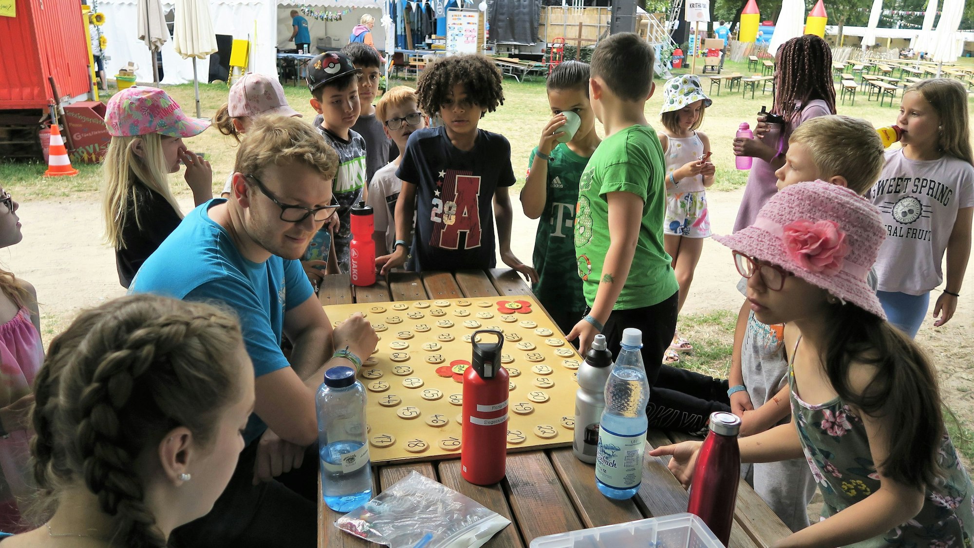 Kinder stehen um einen Tisch herum und spielen ein Spiel.