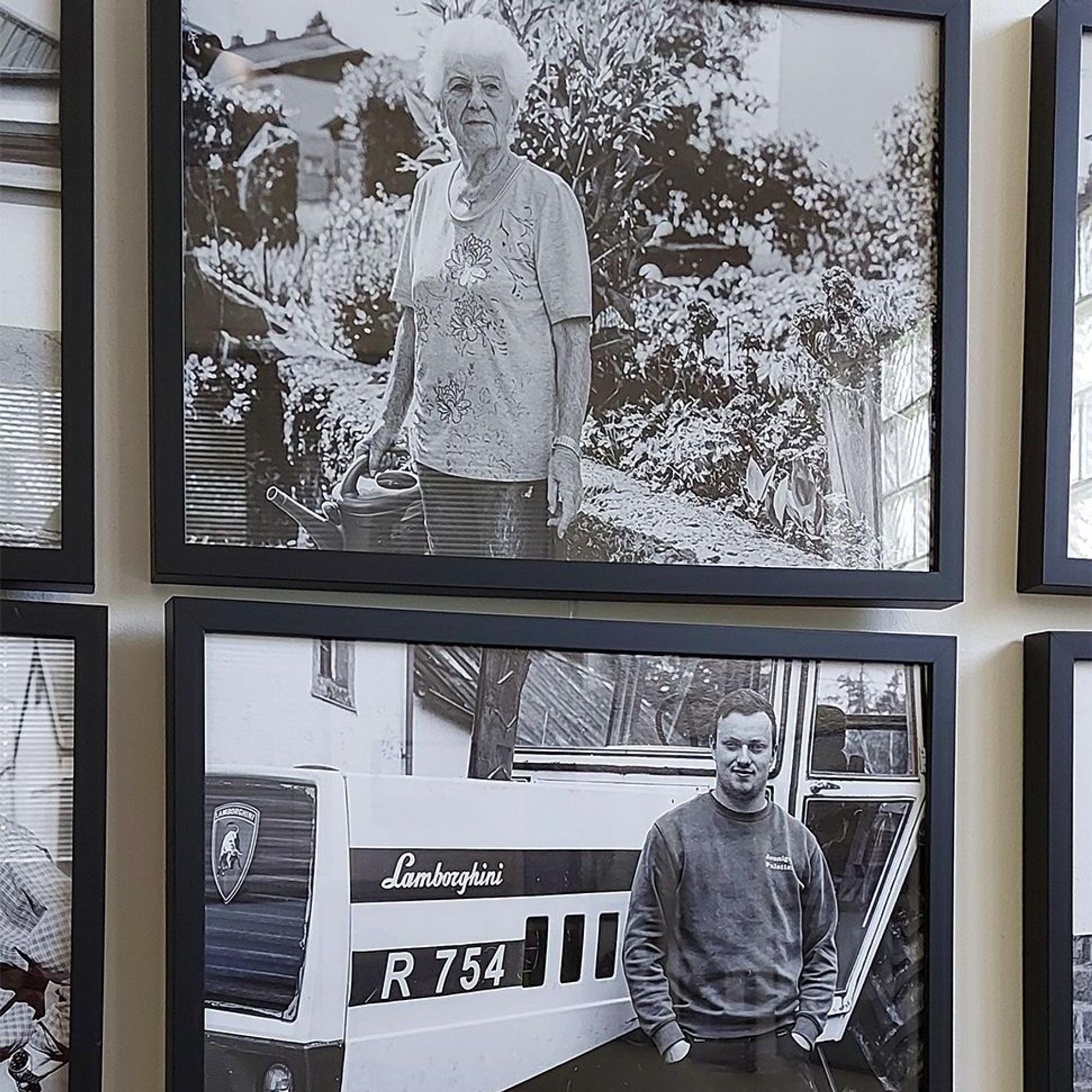 Das Bild zeigt einen Mann und eine Frau, jeweils auf gerahmten Schwarz-Weiß-Fotos, die in einer Ausstellung gezeigt werden.