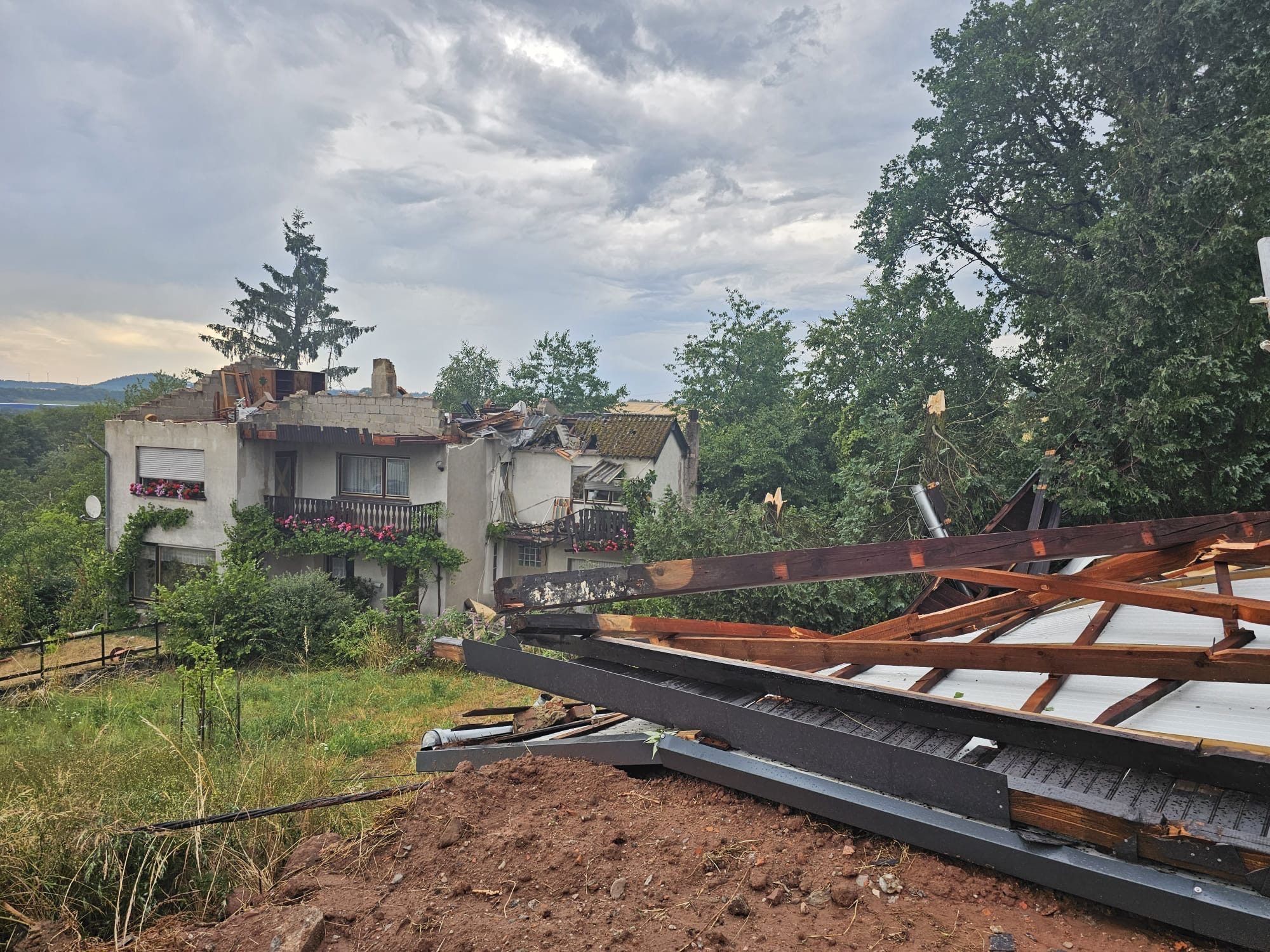 Ein Blick auf stark beschädigte Hausdächer nach einem Unwetter in Asweiler der saarländischen Gemeinde Freisen im Landkreis St. Wendel.
